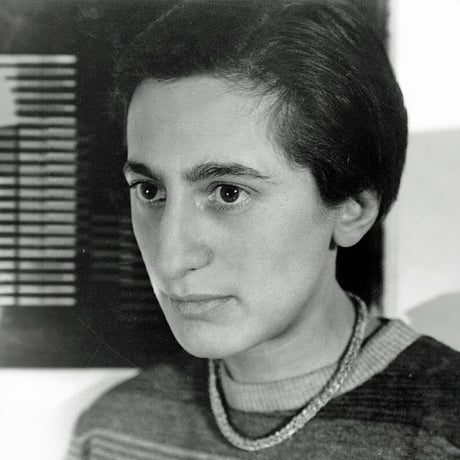 Schwarz-weißes Portrait einer Frau mit kurzen dunklen Haaren, Blick nach rechts, trägt einen Pullover und eine Halskette.