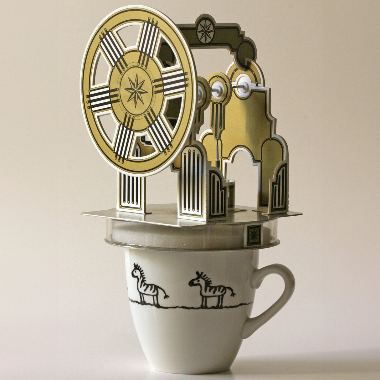 Ein Teetassen-Model mit einem mechanischen Uhrwerk auf der Oberseite.