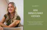 Frau mit langem, gewelltem blondem Haar, lächelnd, in grüner Kleidung, sitzt an einem Tisch.