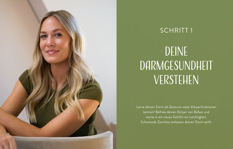 Frau mit langem, gewelltem blondem Haar, lächelnd, in grüner Kleidung, sitzt an einem Tisch.