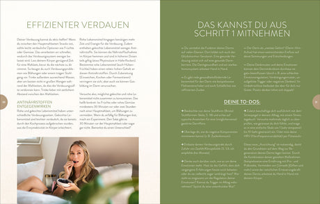 Frau sitzt auf Sofa, isst Beeren aus Schüssel, schaut in Kamera, im Hintergrund helles Zimmer.