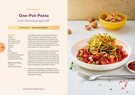 Bunte Pasta mit Zucchini-Spiralen, Tomaten und Walnüssen auf weißem Teller, daneben eine kleine Schüssel mit getrockneten Tomaten.