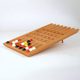 Holzspiel mit bunten Kugeln und mehreren leeren Fächern, auf einem weißen Hintergrund.