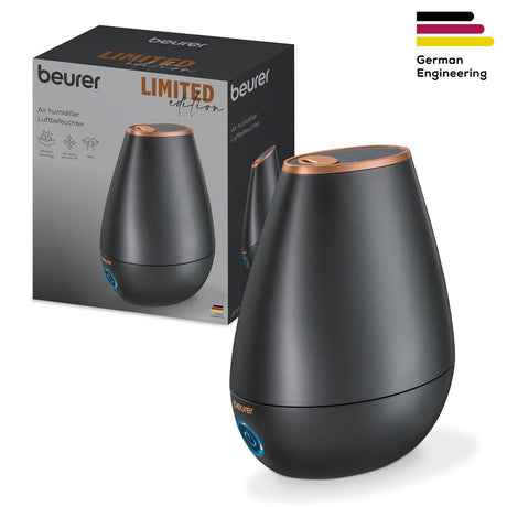 Luftbefeuchter in schwarzer, ovaler Form mit kupferfarbenem Rand, neben Verpackung mit Produktabbildung.