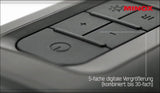 Nahaufnahme eines Tastaturteils mit Text "5-fache digitale Vergrößerung (kombiniert: bis 30-fach)" und "MINOX" in roter Schrift.