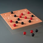 Ein Holzspielbrett mit roten und schwarzen Kugeln, die auf den Spielfeldern liegen.