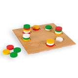 Holzbrett mit bunten, gestapelten Spielsteinen in Rot, Gelb, Grün und Weiß, einige Steine neben dem Brett.