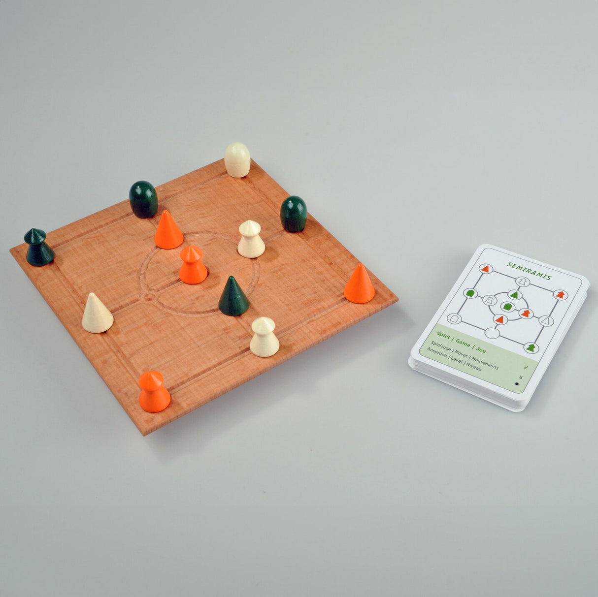 Holzbrett mit bunten Spielfiguren und Spielkarte für das Brettspiel Semiramis.
