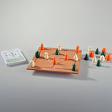 Holz-Tabletop-Feld mit weißen, grünen und orangefarbenen Spielsteinen, Spielkarte links daneben, auf weißem Hintergrund.